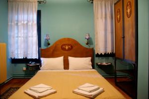 阿尔奈阿House Mitsiou Traditional Inn的一间卧室配有一张床,上面有两条毛巾
