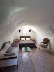 Santa-Reparata-di-BalagnaL'Aghjalle的一间卧室配有一张床、一张沙发和一张桌子