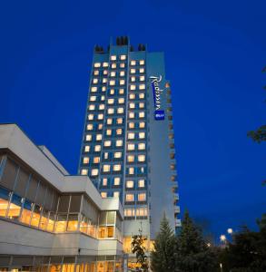 安卡拉安卡拉丽笙布鲁酒店的一座高大的建筑,旁边有一个标志