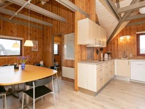 比耶勒高6 person holiday home in Hvide Sande的一间厨房,内设木墙和桌子