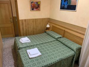 圣塞巴斯蒂安德洛斯雷耶斯若望二十三世旅馆的小客房内的两张床和白色毛巾