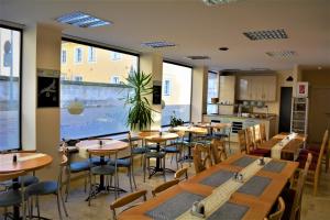 克罗纳赫Economy Hotel Kronach的餐厅设有木桌、椅子和窗户。