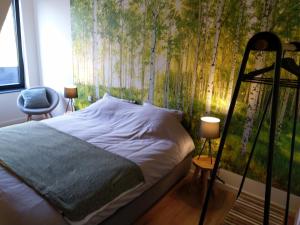 里提B&B Tantine的卧室配有一张带树壁画的床