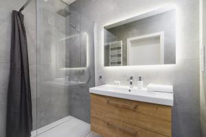 克拉科夫Apartments Supernova near Tauron Arena by Renters的浴室配有盥洗盆和带镜子的淋浴