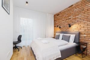 克拉科夫Apartments Supernova near Tauron Arena by Renters的一间卧室设有一张床和砖墙