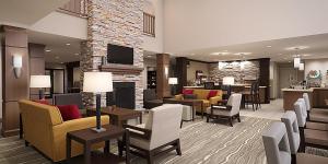苏福尔斯Staybridge Suites - Sioux Falls Southwest, an IHG Hotel的酒店大堂设有桌椅和壁炉