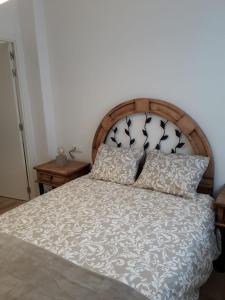 洛格罗尼奥Céntrico y con encanto en tierra de vinos的一间卧室配有一张带木制床头板和枕头的床。
