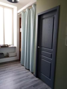 勒比格Gite BR Al Buga的绿色墙壁的房间里,有一道黑色的门