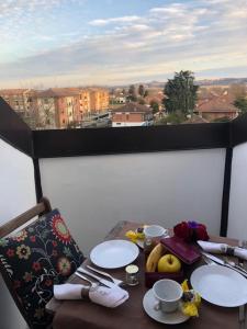 阿斯蒂La mansarda的一张桌子,上面有盘子和餐具,有窗户