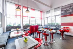 汉堡108酒店的餐厅设有红色的椅子和桌子以及窗户。
