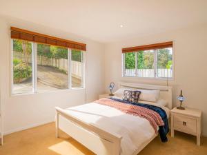 怀蒂昂格Seaview Serenity- Whitianga Holiday Home的一间白色卧室,配有床和2个窗户