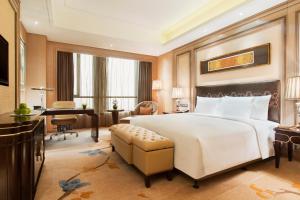 哈尔滨哈尔滨富力万达嘉华酒店的卧室配有一张白色大床和一张书桌