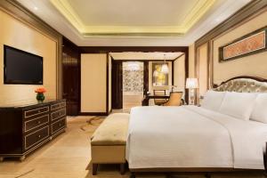 哈尔滨哈尔滨富力万达嘉华酒店的卧室配有一张白色大床和电视。