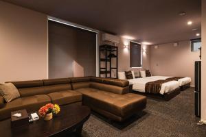 北九州GRAND BASE Moji Nagomi的酒店客房设有一张沙发和一张床