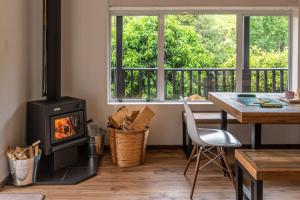 阿卡罗阿La Petite Maison - Akaroa Holiday Home的客厅设有炉灶、桌子和窗户。