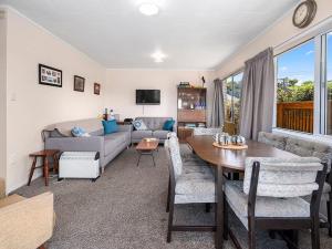 陶波Central Riverside Retreat - Taupo Holiday Home的客厅配有桌子和沙发