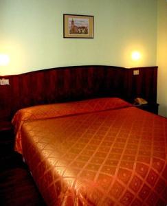 波图格鲁洛阿尔伯格梅里迪娜酒店的一间卧室,在房间内配有一张大橙色的床