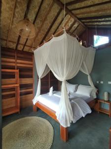克里穆图The Geckos Homestay的一间卧室配有两张床和蚊帐