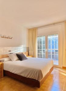 罗萨斯Chalet Port de Roses的一间卧室设有一张大床和一个大窗户