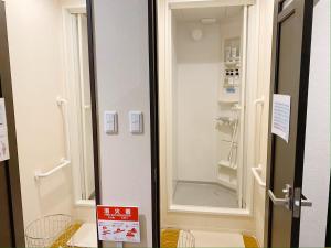福冈尼克库拉旅舍的门旁带步入式淋浴间的浴室