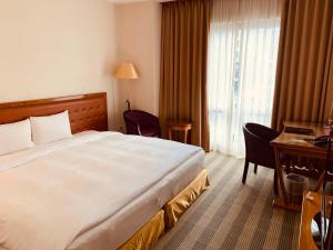 中坜凯都大饭店的酒店客房设有一张大床和一张书桌。
