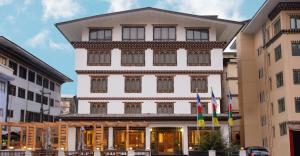 廷布Lemon Tree Hotel, Thimphu的前面有旗帜的大型白色建筑