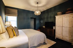 奥尔德尼Blonde Hedgehog的一间卧室配有一张床、一个橱柜和一个吊灯。
