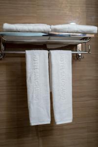 仰光Hotel Sanchaung的在酒店客房内的毛巾架上放置两条毛巾