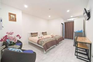 曼谷Parvena Ratchada的卧室配有一张床和一张桌子及椅子