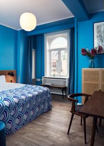 哥本哈根Coco Hotel的一间拥有蓝色墙壁的卧室,配有一张床和一张桌子