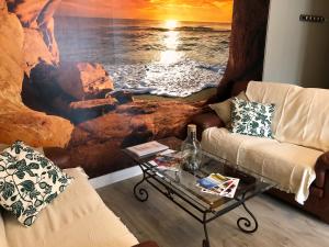 布雷阿勒L' ALBATROS - 2 chambres - 5 personnes - Proximité de la plage的客厅配有海洋绘画