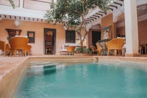 马拉喀什极乐鸟摩洛哥传统庭院住宅的一座带椅子和桌子的别墅内的游泳池