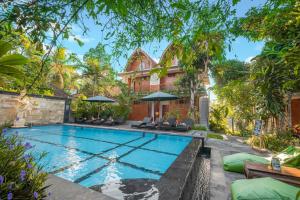乌布古农梅尔塔简易别墅酒店的一座带房子的后院的游泳池