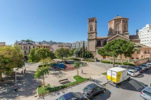 马略卡岛帕尔马Urban Hostel Palma - Albergue Juvenil - Youth Hostel的教堂的景色,停车场有车辆停放