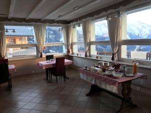 贝尔瓦尔德Hotel Wannenhorn的一间设有两张桌子和窗户的用餐室