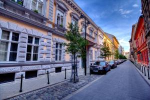 布达佩斯Gellerico Rooms at Horánszky Street的一条街道,汽车停在大楼的一侧