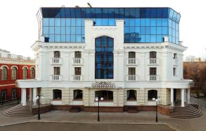 波尔塔瓦Hotel Aristokrat的一座白色的大建筑,带有玻璃建筑
