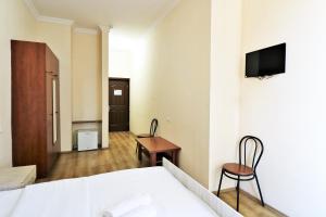 第比利斯Ortachala Palace的酒店客房设有一张床和墙上的电视