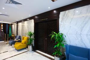 吉达Bait Aldiyafah Hotel Apartments的大堂设有黄色椅子和蓝色椅子