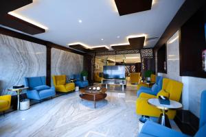 吉达Bait Aldiyafah Hotel Apartments的大堂设有蓝色和黄色的椅子和电视