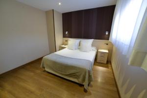 利亚内斯利亚内斯旅游公寓酒店的一间卧室配有带白色床单和枕头的床。