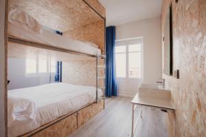 帕洛斯角SubUp Hostel的客房设有两张双层床和一张书桌。