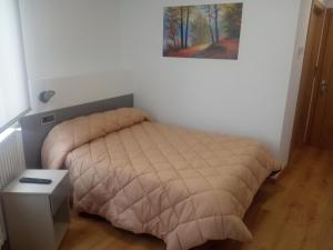 奥伦塞Hostal Outarelo的一间卧室配有一张床、一张桌子和一张图片