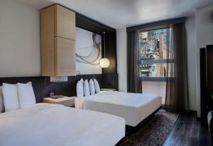 纽约Hyatt Herald Square New York的酒店客房设有两张床和窗户。