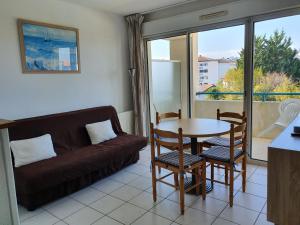 西布勒Appartement Golf et Nivelle avec piscine et parking的客厅配有沙发和桌椅