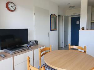 西布勒Appartement Golf et Nivelle avec piscine et parking的客厅配有木桌和电视。