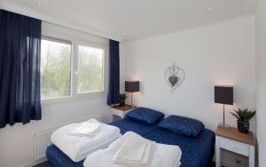 雷讷瑟Siblu Camping de Oase的一间卧室设有两张床和窗户。