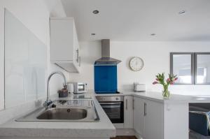 滨海索尔特本Sea Front Apartment的白色的厨房配有水槽和时钟