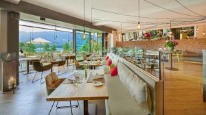 法克湖畔埃格Kleines Hotel Kärnten的餐厅设有配备了桌椅的长酒吧