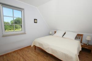 吕根岛上的维克Ostseehaus Odin Doppelhaushälfte的白色的卧室设有床和窗户